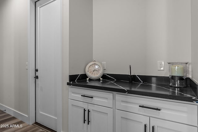 bar featuring white cabinets and dark wood-type flooring