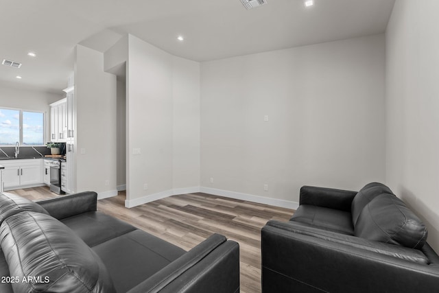 living room with sink and light hardwood / wood-style flooring