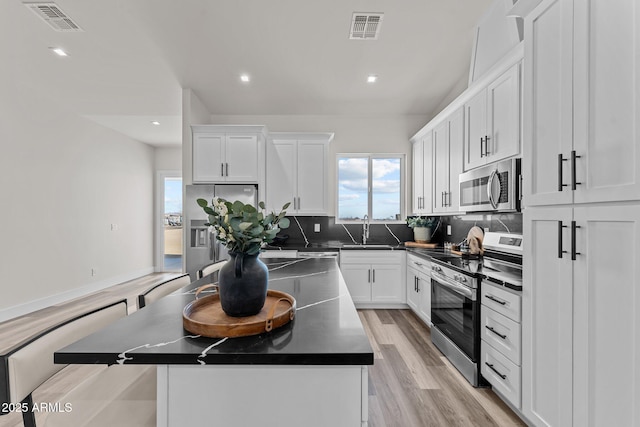 kitchen featuring sink, a kitchen island, white cabinetry, and stainless steel appliances