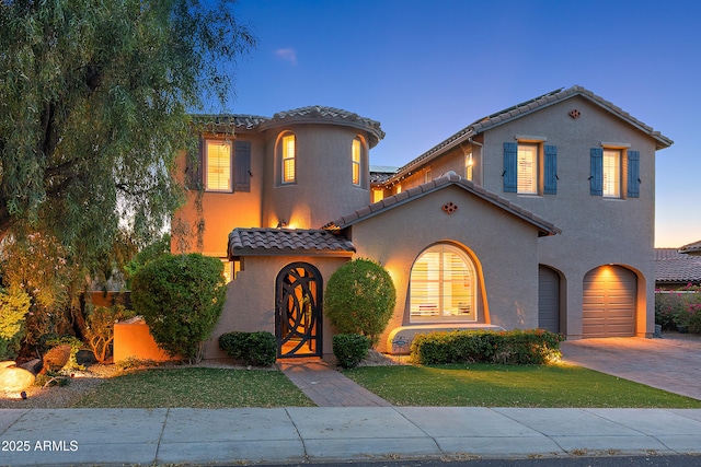 26036 N 85th Dr, Peoria, AZ 85383 - mediterranean / spanish-style home with an attached garage, a tile roof, a front yard, stucco siding, and driveway