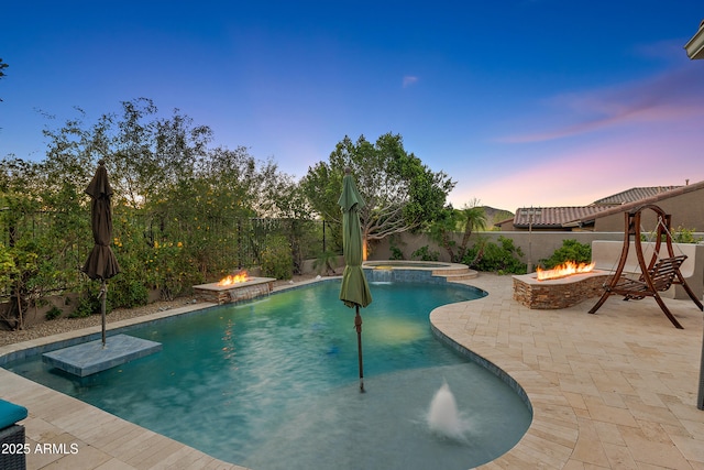 26036 N 85th Dr, Peoria, AZ 85383 - pool at dusk featuring an outdoor fire pit, a patio area, a fenced backyard, and a pool with connected hot tub