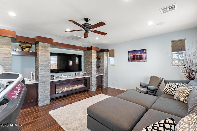 26036 N 85th Dr, Peoria, AZ 85383 - living area featuring dark wood finished floors, ceiling fan, a glass covered fireplace, recessed lighting, and ornate columns