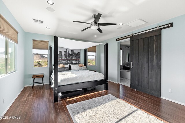 26036 N 85th Dr, Peoria, AZ 85383 - bedroom with a barn door, wood finished floors, recessed lighting, baseboards, and ensuite bathroom