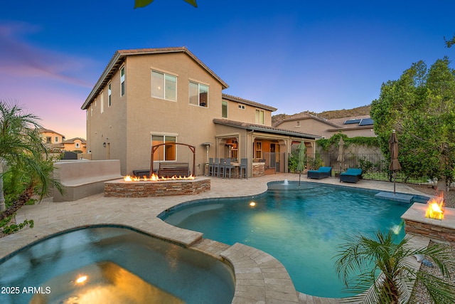 26036 N 85th Dr, Peoria, AZ 85383 - pool at dusk with an outdoor fire pit, a patio, and a pool with connected hot tub