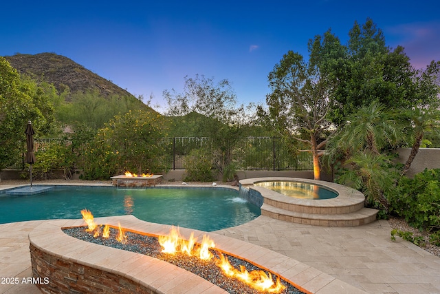 26036 N 85th Dr, Peoria, AZ 85383 - view of swimming pool featuring an outdoor fire pit, a mountain view, a fenced backyard, a pool with connected hot tub, and a patio area