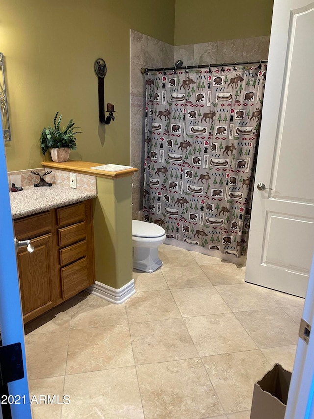 bathroom featuring vanity, toilet, and tile floors