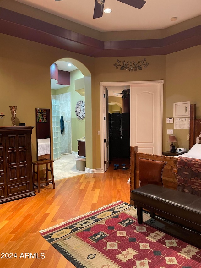 bedroom with light hardwood / wood-style flooring, ceiling fan, and a closet