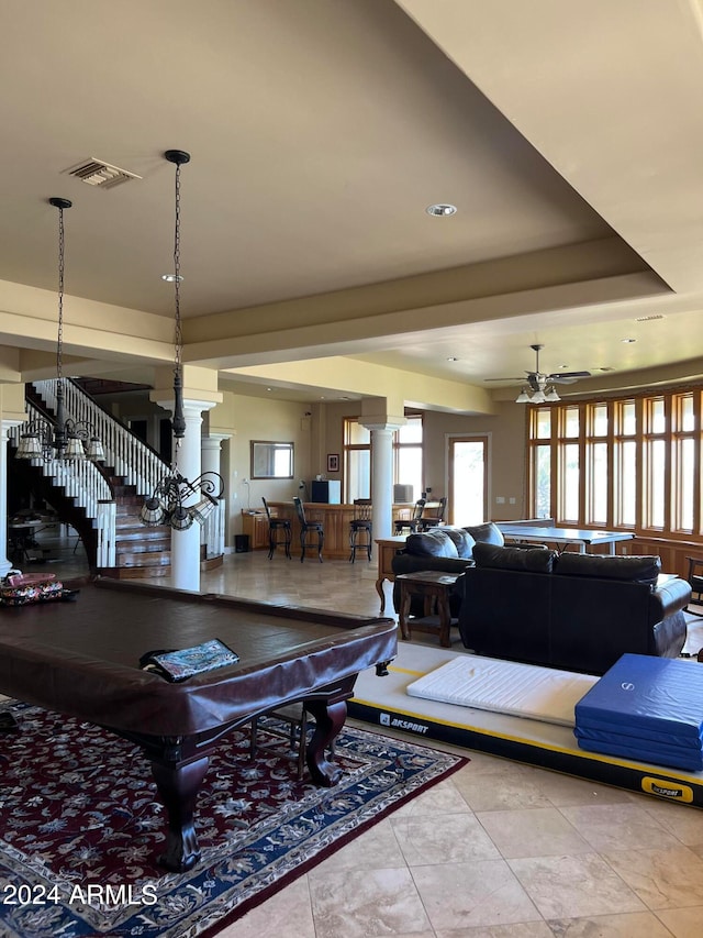 tiled living room featuring pool table, ceiling fan, ornate columns, and a raised ceiling