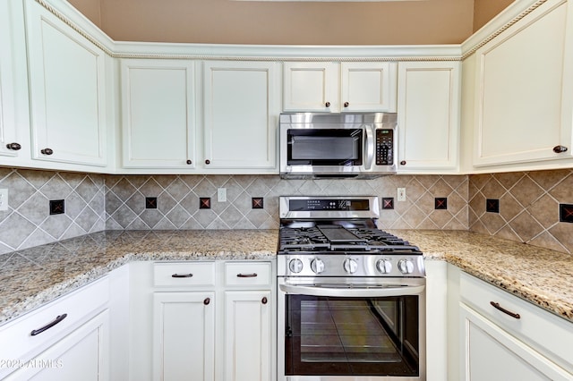 kitchen featuring decorative backsplash, light stone countertops, stainless steel appliances, and white cabinets