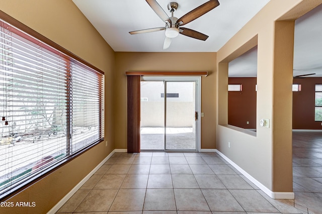 unfurnished room with light tile patterned flooring, baseboards, and ceiling fan