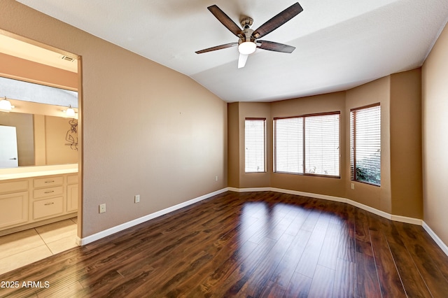 unfurnished room with a ceiling fan, wood finished floors, baseboards, lofted ceiling, and visible vents
