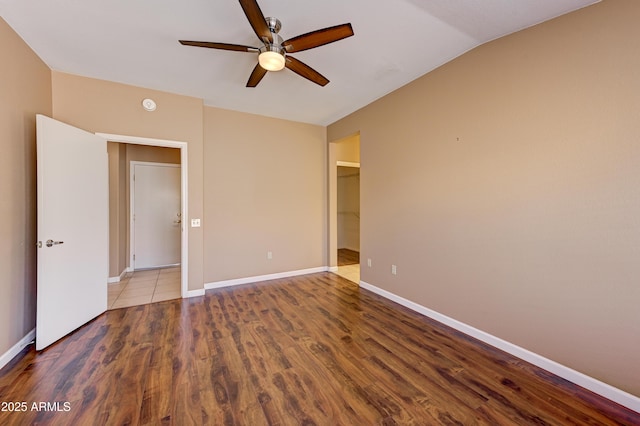 unfurnished bedroom with ceiling fan, baseboards, and wood finished floors