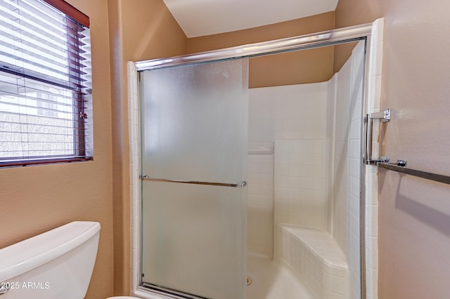 full bath featuring a shower stall and toilet