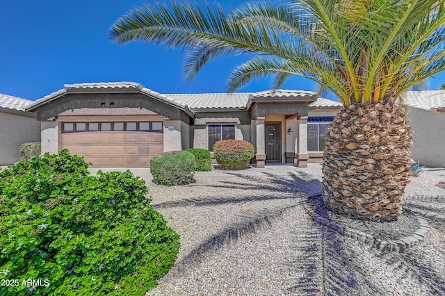 view of front of property with a garage, a tile roof, stucco siding, and driveway