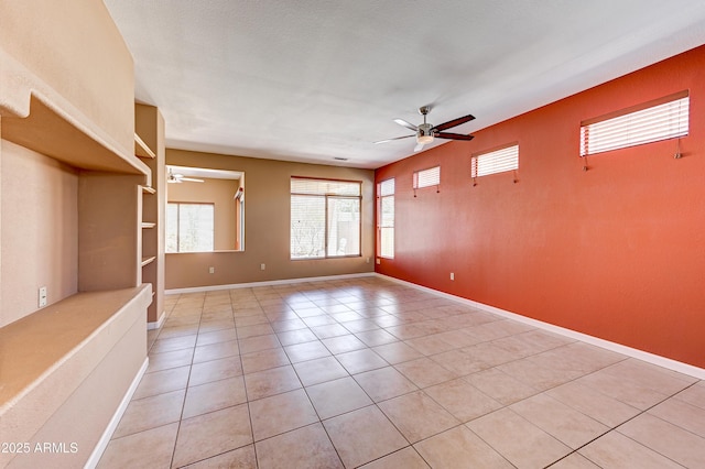 unfurnished living room with light tile patterned flooring, baseboards, and ceiling fan