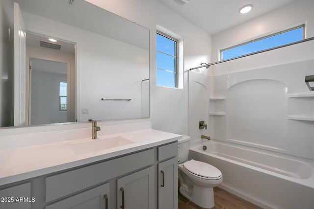 full bathroom featuring toilet, tub / shower combination, vanity, and hardwood / wood-style floors