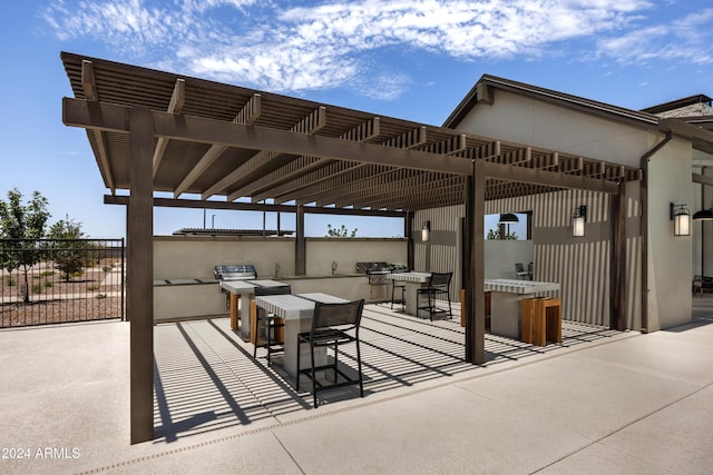 view of patio featuring area for grilling, a pergola, and an outdoor kitchen