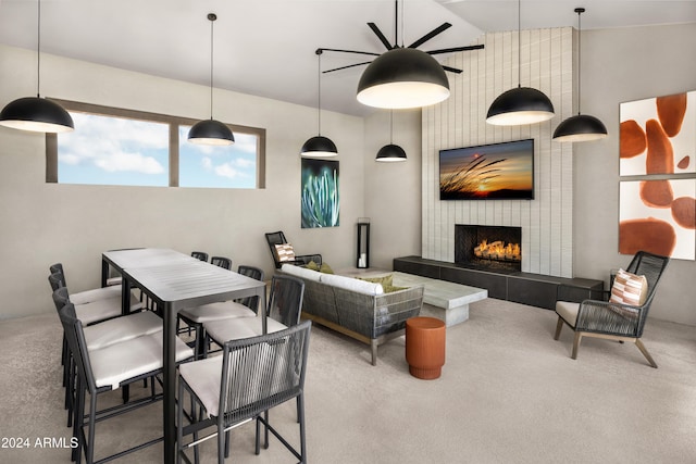 living room with a tile fireplace, vaulted ceiling, and carpet flooring