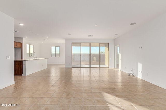 unfurnished room featuring light tile patterned floors and sink