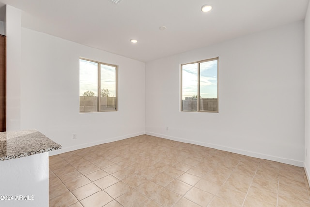 spare room with light tile patterned floors and a healthy amount of sunlight