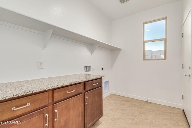 washroom with electric dryer hookup, hookup for a washing machine, and cabinets