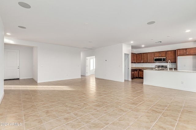 unfurnished living room with sink and light tile patterned flooring