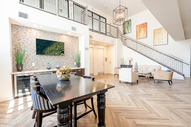 2511 W Queen Creek Rd Unit 325, Chandler, AZ 85248 - dining space with wine cooler, a chandelier, a high ceiling, and stairway
