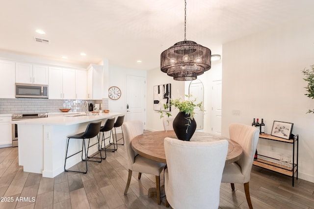 2511 W Queen Creek Rd Unit 325, Chandler, AZ 85248 - dining space with wood finished floors, a chandelier, and recessed lighting