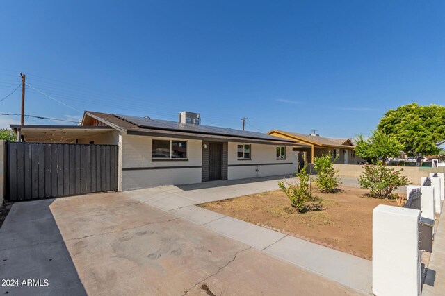 ranch-style home featuring solar panels