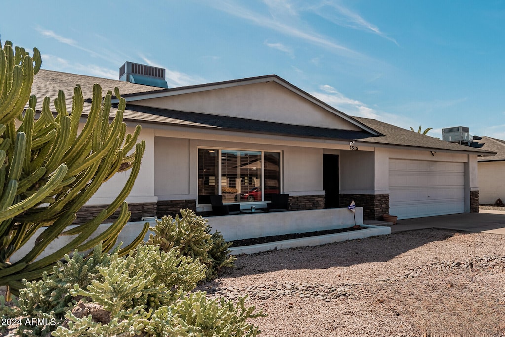 view of front facade with a garage and central air condition unit