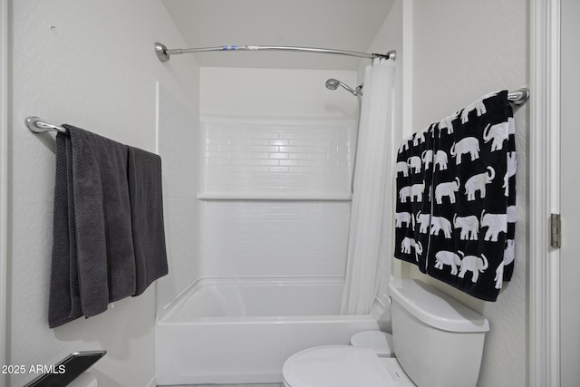 bathroom featuring shower / tub combo and toilet