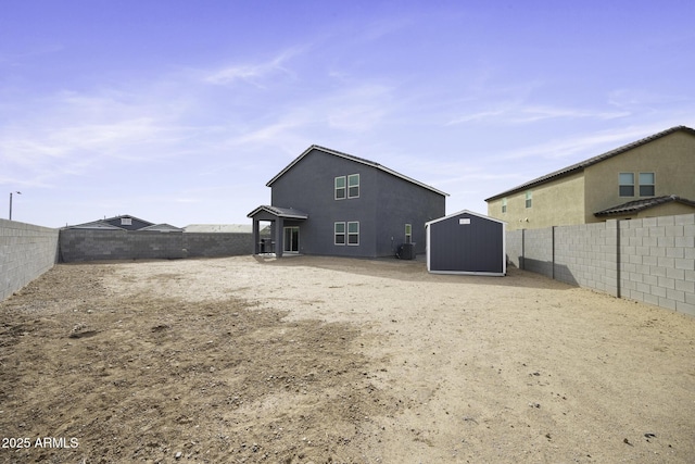 back of property featuring a storage shed and central AC unit