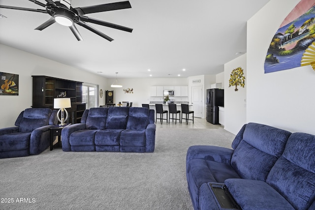 carpeted living room featuring ceiling fan