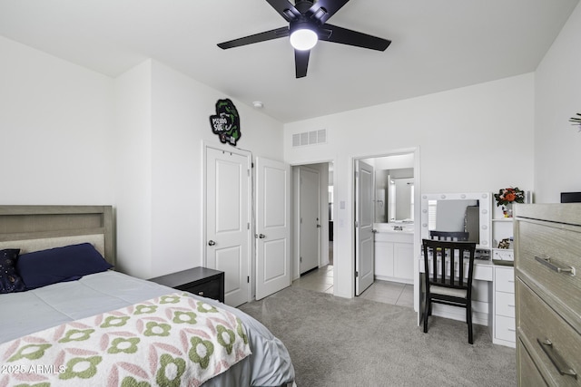 carpeted bedroom with ceiling fan and ensuite bath