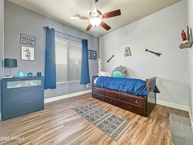 bedroom featuring ceiling fan, baseboards, and wood finished floors