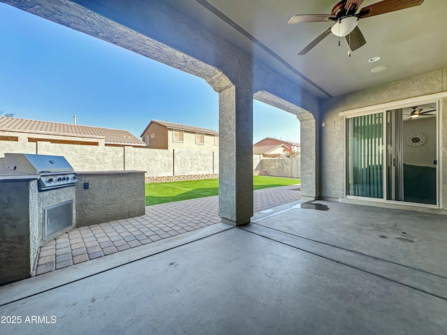 view of patio featuring a fenced backyard, ceiling fan, exterior kitchen, and area for grilling