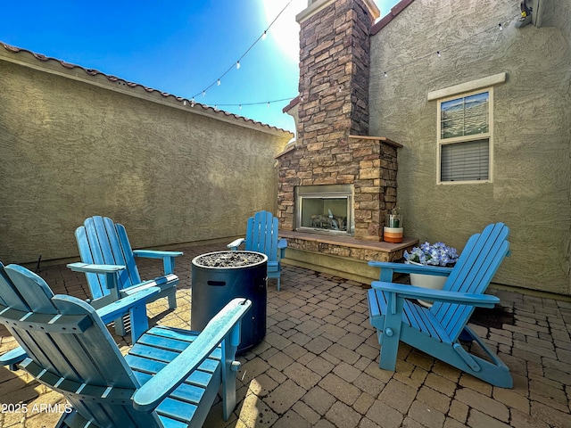 view of patio featuring an outdoor stone fireplace