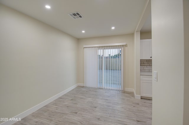 empty room with light hardwood / wood-style flooring