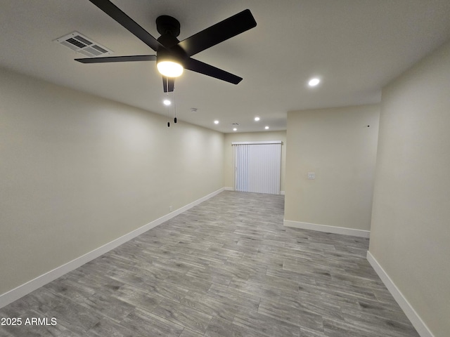 empty room with ceiling fan and light hardwood / wood-style flooring