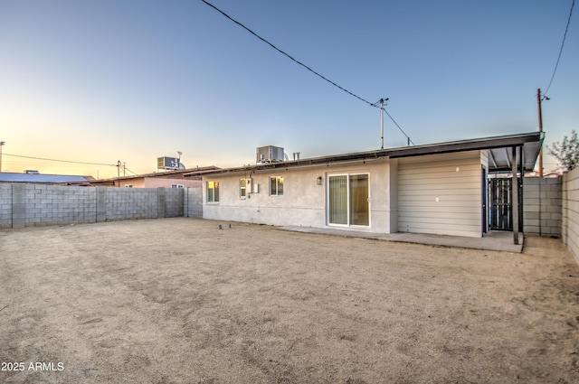 back house at dusk featuring cooling unit