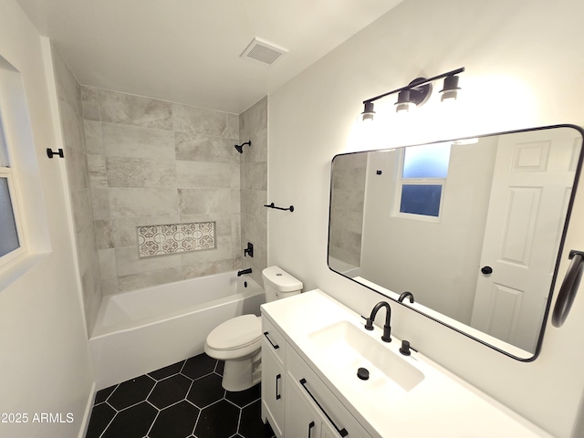 full bathroom featuring vanity, toilet, tiled shower / bath combo, and tile patterned flooring