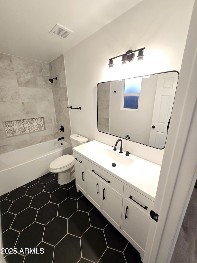 full bathroom featuring vanity, tiled shower / bath, tile patterned floors, and toilet