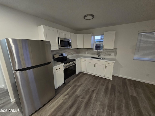 kitchen with sink, backsplash, white cabinets, dark hardwood / wood-style flooring, and stainless steel appliances