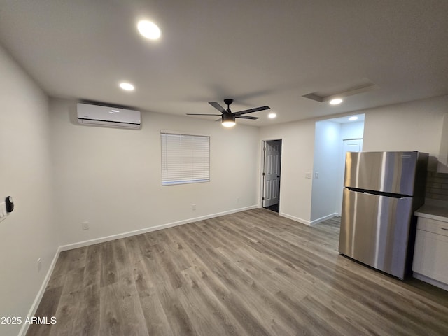 interior space featuring light hardwood / wood-style floors, an AC wall unit, and ceiling fan