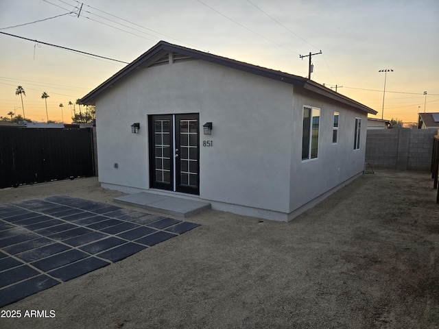 back house at dusk featuring a patio area