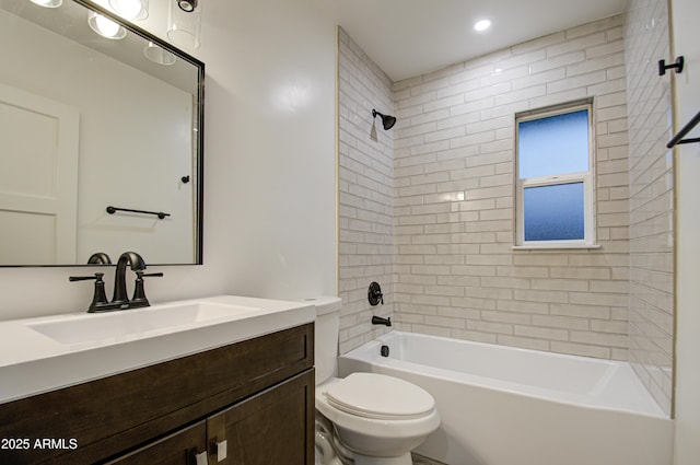 full bathroom with vanity, tiled shower / bath combo, and toilet