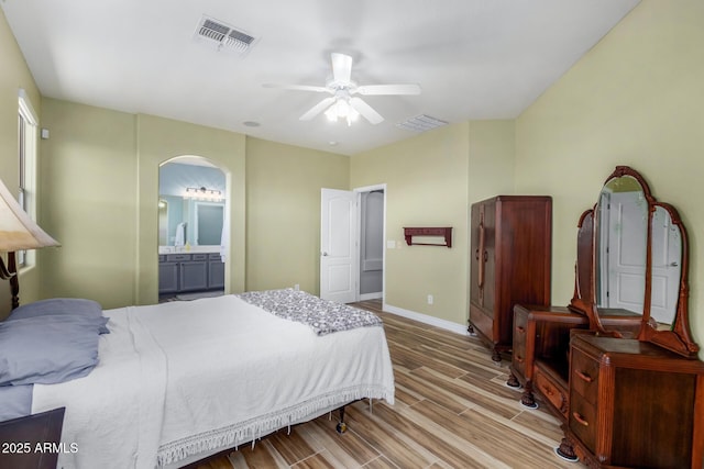 bedroom with ceiling fan, light hardwood / wood-style flooring, and ensuite bath