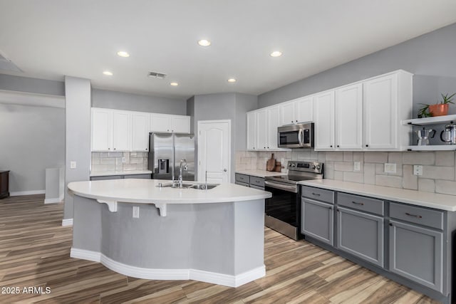 kitchen featuring tasteful backsplash, appliances with stainless steel finishes, and white cabinetry