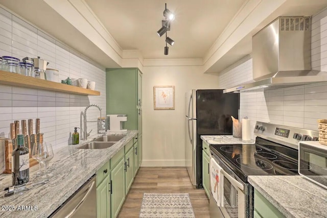 kitchen featuring green cabinets, wall chimney exhaust hood, appliances with stainless steel finishes, open shelves, and a sink