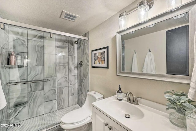 full bathroom featuring visible vents, toilet, vanity, a shower stall, and a textured ceiling